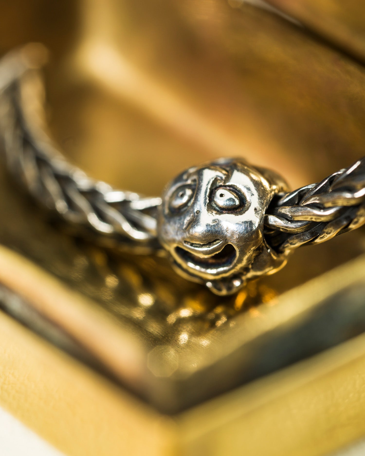 Close-up of a silver bracelet with the first silver bead faces on a gold background