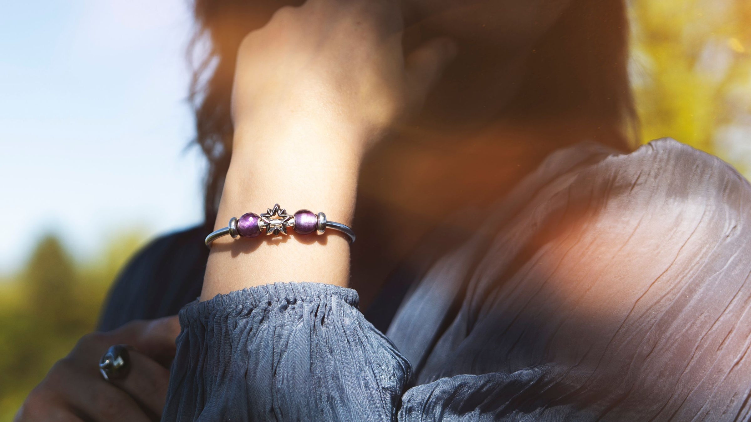 Woman wearing silver bangle with gemstone and silver beads